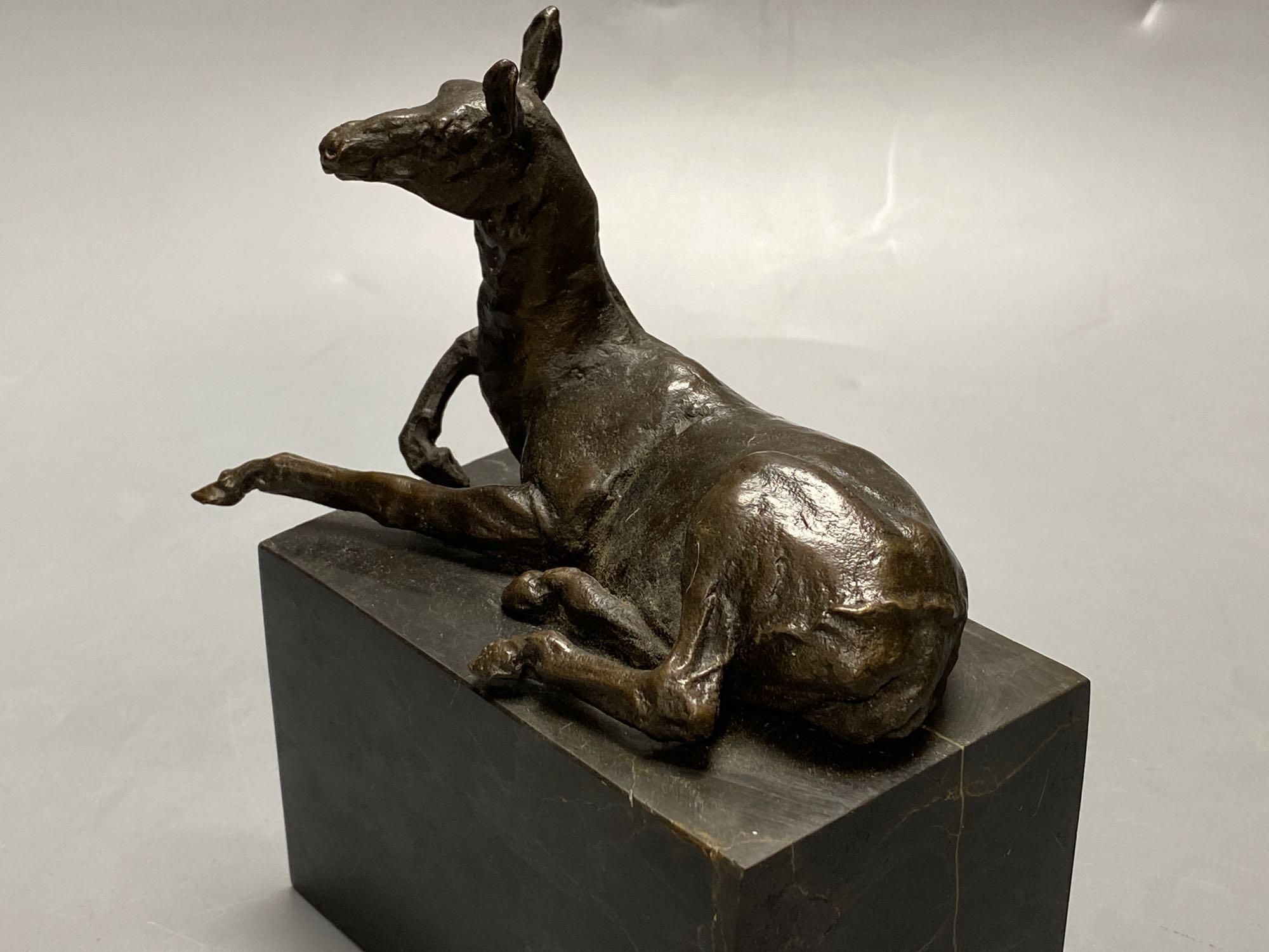 A bronze model of a recumbent mule, indistinctly signed, on marble plinth, width 12cm